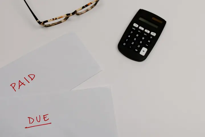 Masa üzerinde hesap makinesi ve ödeme notları